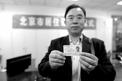 吴先生在展示刚刚领取的北京市居住证.京华时报记者潘之望摄
