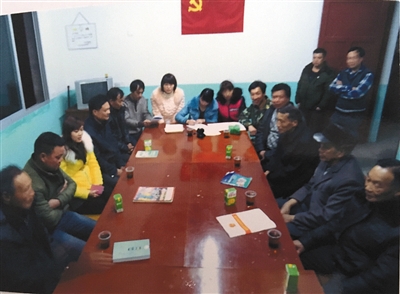 庄里村两委散会时的相片,图中穿迷彩服者是周炳耀。这是他为数未几的事情照之一。
