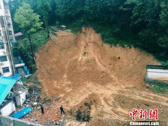 连日遭遇暴雨的南京市,当地郊区一栋企业宿舍旁的山体发生滑坡险情。 陈欢 摄