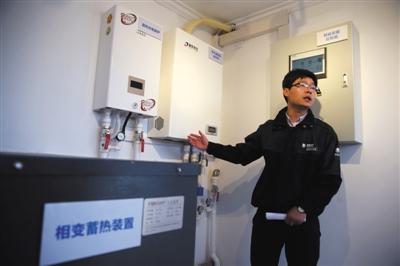 14日,通州区崔家楼村煤改电演示区,作业人员引见更节能的电取暖和设施——氛围源热泵。