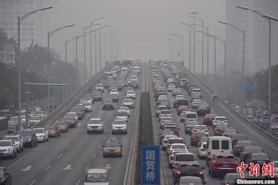 11月18日，北京城区因污染物扩散条件较差于17日发布的今冬首个雾霾橙色预警仍将持续。据气象局预测，目前一股强冷空气正在“候场”，预计11月19日夜间至11月21日白天，将有一次明显雨雪天气，并有大幅度的降温。图为北京东三环车辆行驶缓慢。中新网记者 金硕 摄