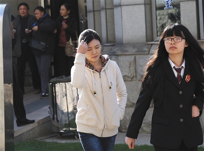 2013年11月7日下午，取保候审的罗菲（左）在法院工作人员带领下走进北京市第二中级法院受审。资料图片/新京报记者 王贵彬 摄