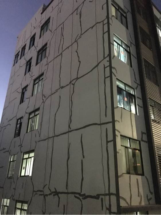 云南林业职业技术学院一宿舍楼出现大面积裂缝，修补后，墙体留满形似“绷带”的痕迹。微博 @直播云南 图