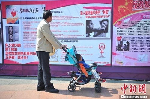 资料图：2016年3月1日，市民在广西南宁市民族广场观看反家暴资料。 中新社记者 胡雁 摄