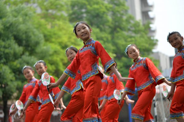内蒙古呼和浩特市新城区满族小学学生在操场上展示满族服饰。新华社