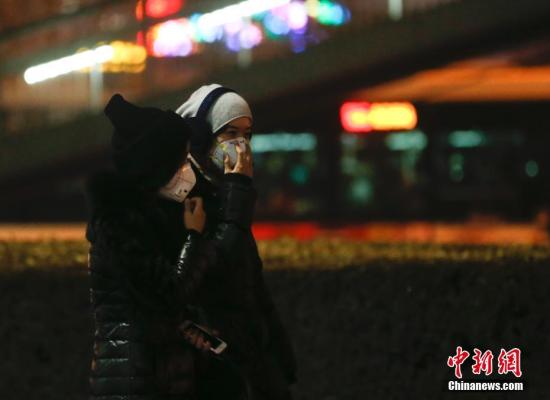 12月16日，北京民众戴防雾霾口罩出行。北京将在当日20时至21日24时启动空气重污染红色预警。中新社记者 杜洋 摄