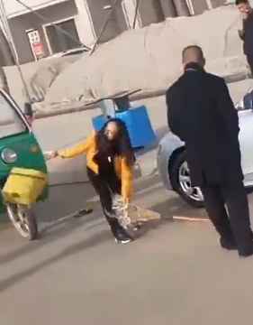 女司机摔砸环卫工人手机后,将其清洁工具抛开。 视频截图