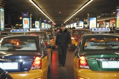 26日，晚9时许，执法人员在T2航站楼外对营运的出租车进行执法检查。 新京报记者 彭子洋 摄