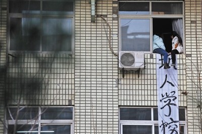 得知无法报考护士资格证,陕西航天职工大学两名女生坐上了4楼教室的窗台讨要说法,后被民警劝下。图/视觉中国