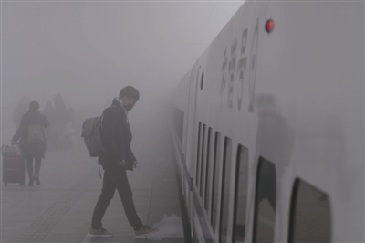 浓雾中，一名男子走向高铁供图/视觉中国