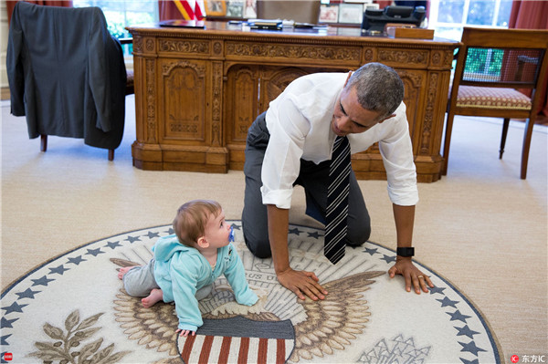 奥巴马趴在椭圆办公室的地毯上，陪白宫发言人柏莎琪的女儿Vivi玩耍。