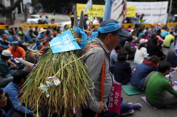 当地时间2016年9月22日，韩国首尔，当地Daehakro农业联盟农民身背水稻上街游行，抗议粮食进口，要求上调最低价格。 东方IC 资料