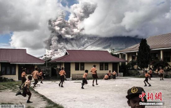 远处的火山喷出大量火山灰，小学生们仍在操场上淡定玩耍。