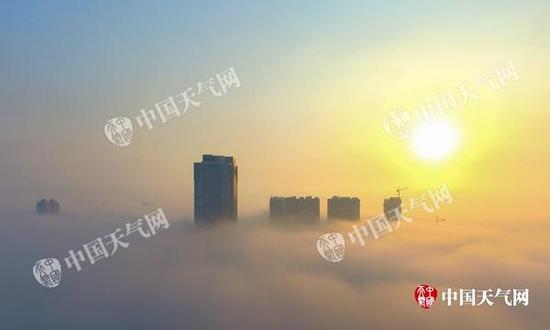本周末，全国大部地区气温回升暖如阳春。图为航拍钦州漂亮的平流雾日出。（摄影：李斌喜）