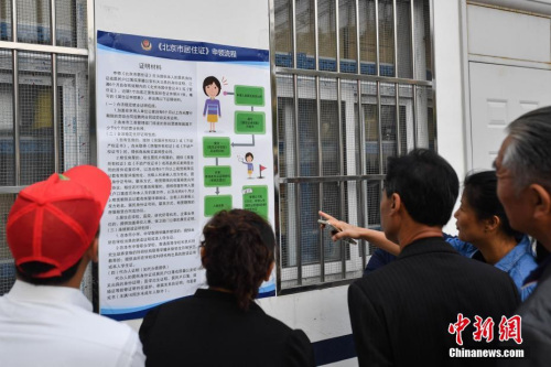 资料图：民众阅读办理居住证的相关要求细则。 中新社记者 崔楠 摄