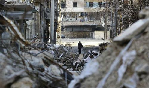 1月21日，在叙利亚北部城市阿勒颇，一名男子在建筑物废墟间行走。（新华社/法新社）