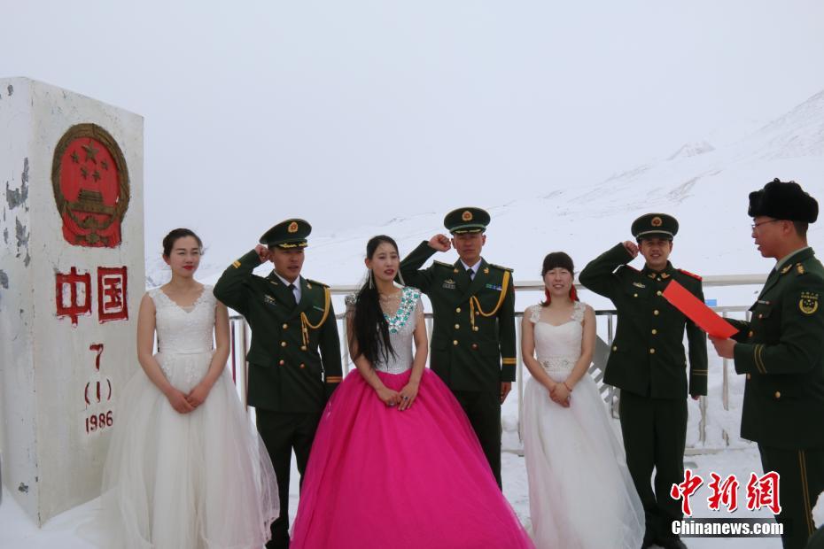 当日上午,红其拉甫边防检查站三名新婚夫妇乘车来到前哨班,穿上了专程从三百多公里外的喀什市租来的婚纱,在官兵们的掌声和祝福声中,三对新人走出前哨班,来到位于中巴边界的7号界碑前。图为三对新人在7号界碑前庄严宣誓表达对爱情的忠贞不渝。 李康强 摄