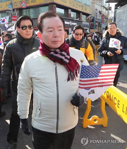 韩国执政党自由韩国党下届总统竞选人(只是表明意向)李仁济手拿美国国旗参加“挺朴”集会