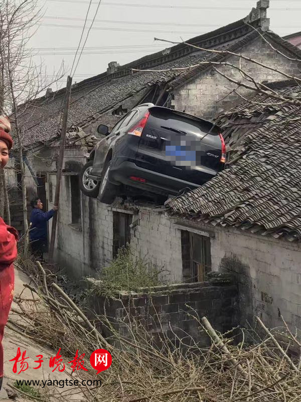原标题:泰州离奇车祸:为避让三轮车 轿车飞上三米高屋顶