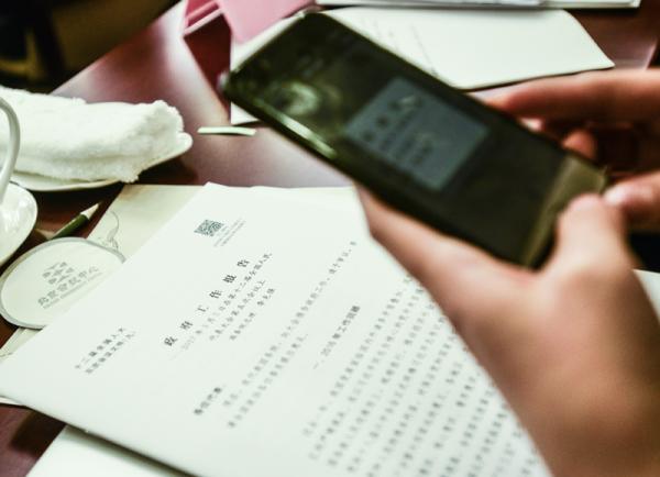 3月5日，北京会议中心，一名记者扫描政府工作报告文本上的二维码获取信息。