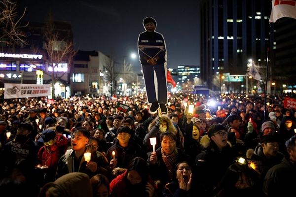 韓國民眾高舉自己製作的樸槿惠淪為囚徒的牌子在燭光集會上 韓國《民族日報》 圖