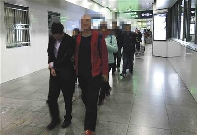 3月15日，涉嫌发送诈骗短信的三家技术公司的12名嫌疑人被警方押解回京。警方供图
