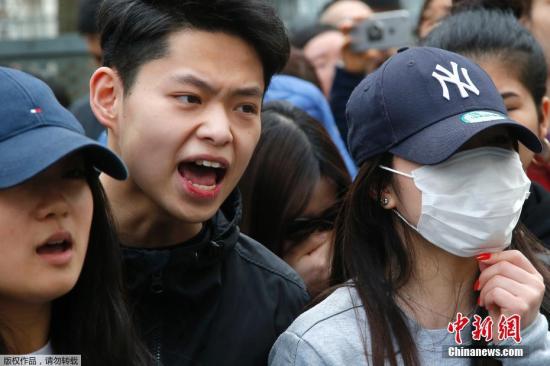 当地时间28日,在法国巴黎的亚裔民众在巴黎警察局门外与法国防暴警察对持。