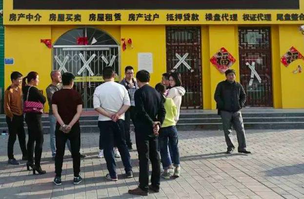 安新县湿地华城楼盘外聚集的外地购房者,房产中介已贴上封条。