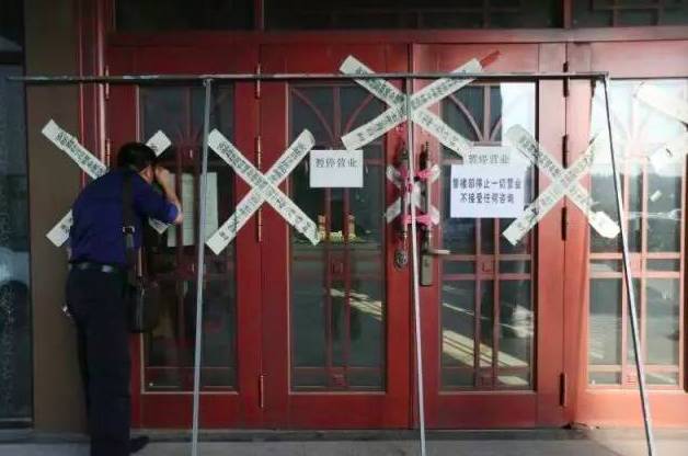 一名外地购房者在明珠湾楼盘销售中心外向内观看。
