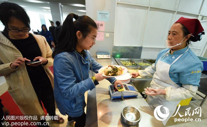 4月10日,学生在杭州师范大学的“2元盖浇饭”窗口购买午饭。