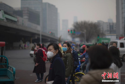 资料图：3月20日，北京市民在雾霾中出行。中新社记者 刘关关 摄