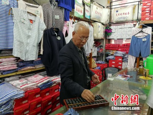 61岁的售货员张志国至今仍在使用算盘 中新网记者 张尼 摄