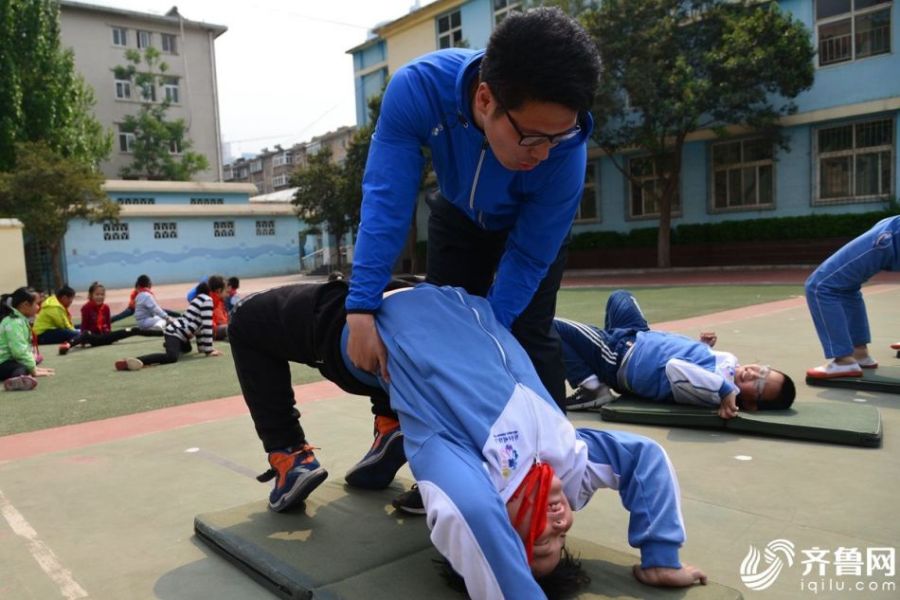 “7-12岁的孩子灵敏度是最好的，这时候训练，既能让孩子变得更灵活，又能增强力量，同时提高孩子自我保护意识，避免在运动中受伤。”体育老师邹老师介绍道。但每个学生的身体素质不一样，学校老师只教授学生最标准规范的动作，在保证安全的情况下，学生尽最大努力练习。图为老师帮助学生矫正动作。 （齐鲁网记者 张煜晴 韩莹 实习记者 马金龙 通讯员 张春蕾）