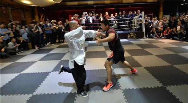 4月27日，格斗教练徐晓冬（右）在一场比试中“秒杀”太极拳师雷雷。