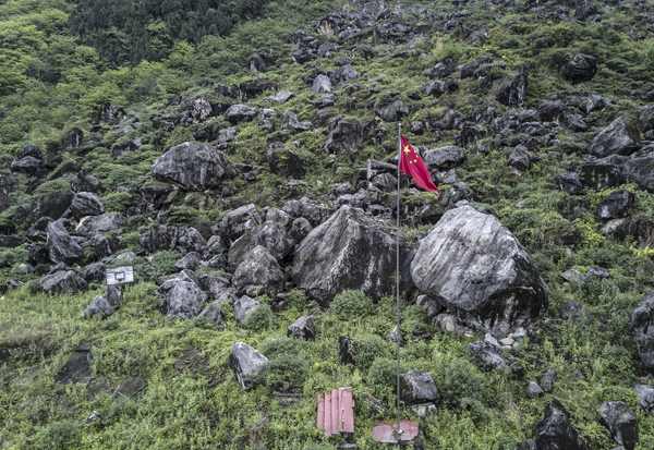 景家山在地震时崩塌，巨大的山石将北川中学新区茅坝中学整体掩埋，只剩一支国旗杆和一个篮球架，上千名师生遇难。 视觉中国 图