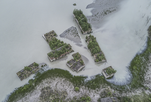 地震后形成的唐家山堰塞湖将北川县漩坪乡完全淹没，直至近些年水位退去后，才见到部分建筑的屋顶。 视觉中国 图