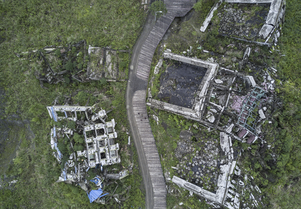 如今北川县城已成为地震遗址景观，在损毁的楼房之间修有一条栈道，供游客穿行。 视觉中国 图