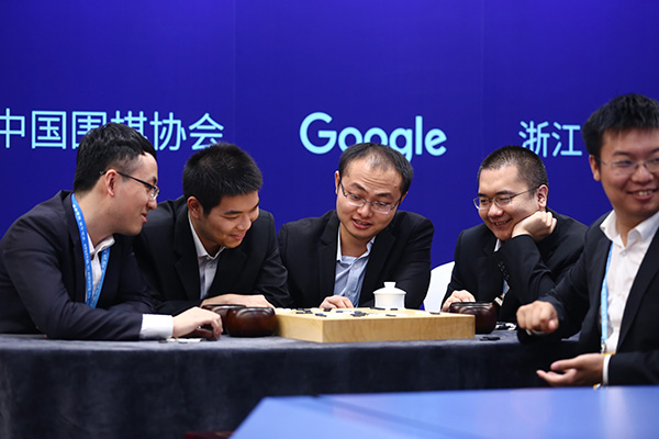 在比赛过程中,围棋“天团”内部气氛相对轻松,讨论热烈,不过局势严峻。比赛进行到1个小时,“天团”内部就多次陷入讨论和矛盾,耗时过长。其中有个插曲是,周睿羊起身应该是去洗手间,为AlphaGo执棋黄世杰博士露出了“迷之微笑”。陈耀烨赶紧过去帮忙落子节约时间。