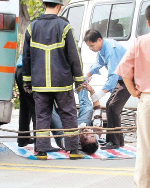 救援人员从公交车里抬出遇难男乘客的尸体.