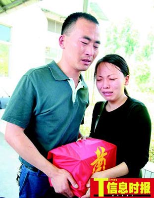 5月11日,在惠州市殡仪馆内,杜某和丈夫王先生抱着女儿梦雨的骨灰盒
