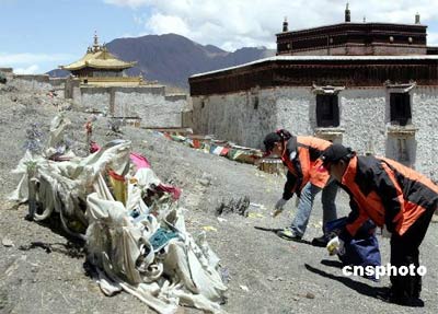 去年5月27日，“2006地球第三极珠峰大行动”志愿者一行从日喀则出发，踏上前往定日县和珠峰的行程。 沿途中志愿者们对遗留在谢通门县土路段的白色垃圾及废弃物进行了清理工作。许多队员顾不上戴上手套就赤手去捡被游客丢弃的食品包装、易拉罐等废弃物，感动了当地许多藏族同胞。图为志愿者们在捡垃圾。 中新社发 陈斌 摄