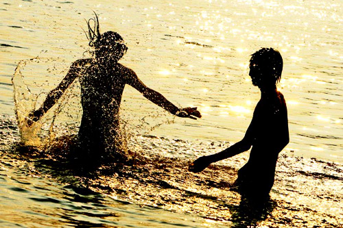 两个少年在波光粼粼的湘江中戏水