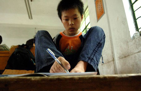 5月28日,无臂少年曹磊在课堂上用脚写字新华社发