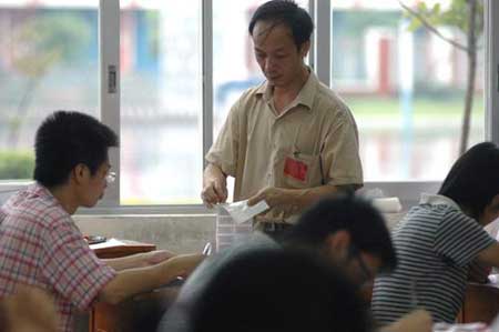 广西柳州市柳州高中，高考监考在向考生分发考试用具。图片来源：CFP