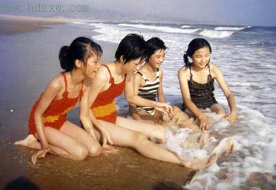 小燕（左一）与儿时的伙伴在海边嬉戏