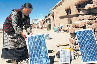 这是西藏普兰县霍尔乡牧民在调试太阳能发电硅光板.