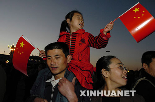 10月15日，北京天安门广场举行升国旗仪式。这是来自山东济宁的王嘉鑫小朋友与家人一起观看升旗仪式。