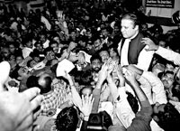 11月25日，在巴基斯坦东部城市拉合尔的机场，巴流亡前总理纳瓦兹·谢里夫（右）与支持者见面。新华/法新 