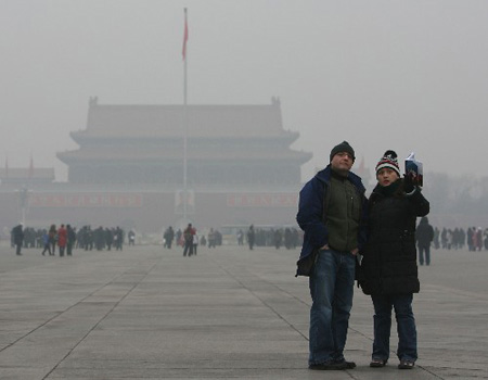 资料图片：12月27日，游客在北京天安门广场游览。当日，雾霾笼罩京城。这是北京连续出现雾霾天。24日开始缠绕北京的雾气在25日下午演变成了“霾”，空气变得干燥，空气质量随之严重下滑。(新华社记者