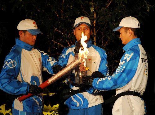 图文:奥运圣火在巴黎传递 护卫手点燃火炬